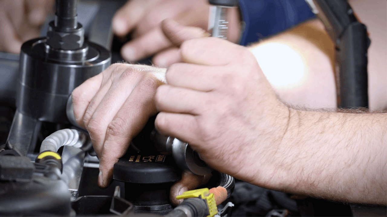 Hände arbeiten am Motor